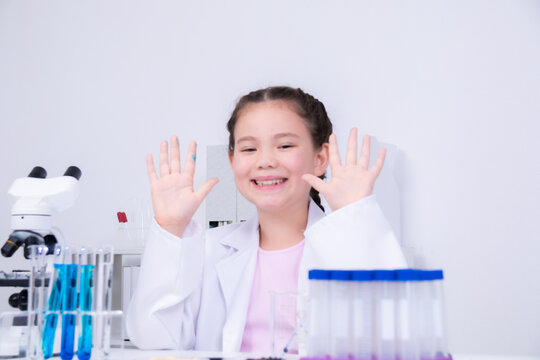 Learning and education for Asian student in classroom where children engage in interactive experiment using laboratory equipment including test tube, beakers, dropper with curiosity and concentration