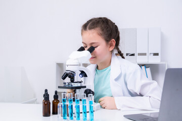 Young student in white coat using microscope, excited expression, observing exposure to biology, chemistry, and scientific equipment, education science class learning by activities in laboratory