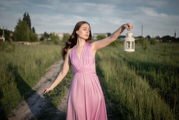On a summer afternoon, a girl picks lupines in the field.