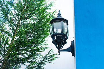 A decorative street lamp on the vibrant blue wall