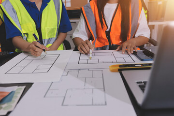 Closeup of team of industrial engineers meeting analyze machinery blueprints consult project on table in manufacturing factory. Working in manufacturing plant or production plant.