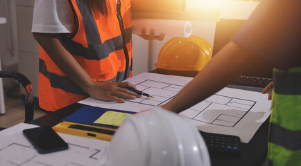 Closeup of team of industrial engineers meeting analyze machinery blueprints consult project on...