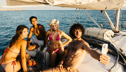 Group of friends enjoying refreshing drinks, taking selfies, and hanging out together on a sailboat...