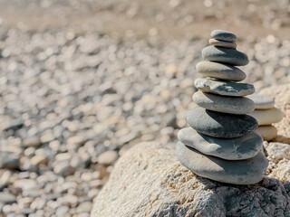 Stacked flat round stones sculpture on Aphrodite’s Beach in Cyprus symbolizing balance, harmony, and natural art in a peaceful coastal setting