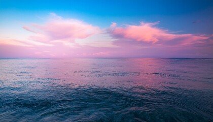 Fototapeta premium the ocean is calm and the sky is a pink color