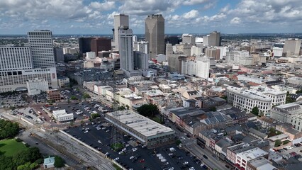 Aerial drone view of downtown New Orleans, Louisiana city city skyline office towers beside the Mississippi River with sunshine and fluffy clouds during a summer heat wave