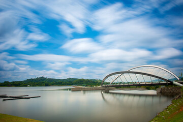 Modern skyline of Putrajaya, Malaysia with tall towers and calm lake under dramatic blue sky and...