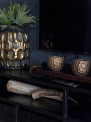 Interior styling display with pineapple vase, hexagonal ceramic objects, and decorative items on black metal shelving