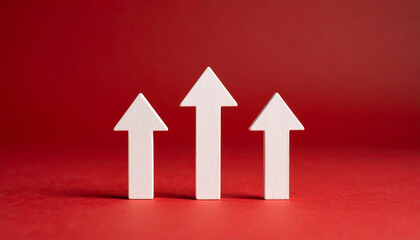 Three white wooden arrows rise up on dark red background. Investment, business growth.