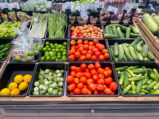 RAYONG, THAILAND - JUNE 21, 2025 : Fresh organic vegetables in basket for selling in the supermarket. Lemon, Tomato, Cucumber, Thai eggplant, Long beans, Lemon grass, Chilli