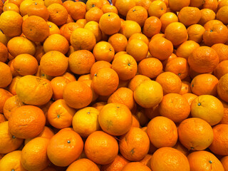 Close up of fresh organic orange in wooden basket for selling in the supermarket.