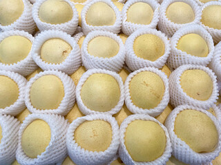 Close up of Chinese pears wrapped with white wrapping paper for selling in supermarket