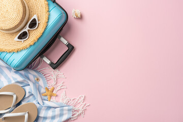 Flat lay of vacation items including blue suitcase, sunglasses, hat, and beach essentials