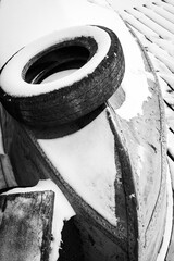 Snow-Covered Boat and Tire in Rural Winter Composition