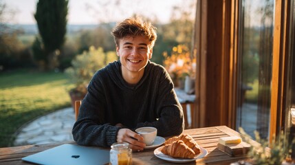 A young man having breakfast on the terrace of a countryside house