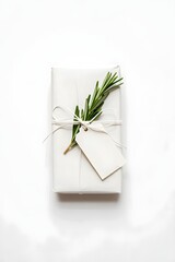 White wrapped gift box with rosemary sprig and blank tag perfect for holiday or birthday