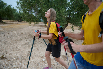 Young Couple Enjoying a Scenic Hiking Adventure Among Nature with Trekking Poles