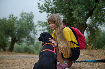 Young Woman Enjoying a Nature Hike with Her Dog and Backpack