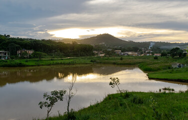 Sunset between clouds, with a beautiful evening on the edge of a lake in the rural area of ​​the municipality of Esmeraldas, Minas Gerais.