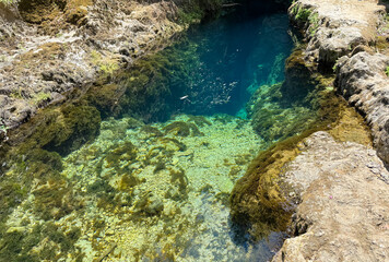 Natural karst spring with transparent turquoise water and underwater rocks in Sardinia