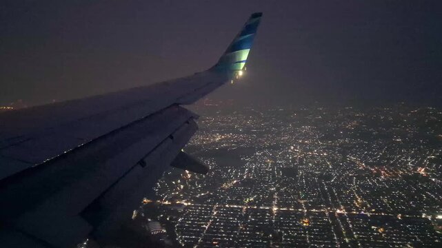 aerial view of jakarta city taken from inside of flying airplane at night