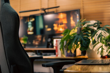 A warm and cozy desk setup featuring triple monitors, notebook, microphone, and green plants, styled in a minimalist Japanese aesthetic for creative work.