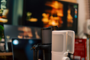 A warm and cozy desk setup featuring triple monitors, notebook, microphone, and green plants, styled in a minimalist Japanese aesthetic for creative work.