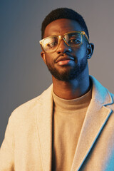 Stylish young Black man in glasses wearing a beige coat against a colorful background, showcasing...