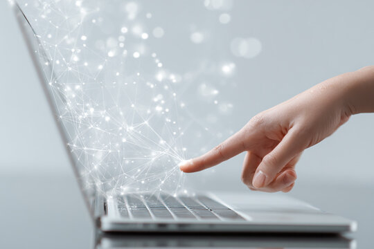 Finger touches laptop, unleashing network. Concept for marketing, web design, or editorial use on technology, internet, connectivity.
