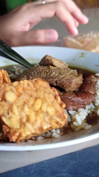 Rawon is a traditional Indonesian beef soup with black keluak broth, rich aroma, and tender meat, usually served with rice, egg, and sambal