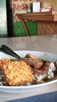Rawon is a traditional Indonesian beef soup with black keluak broth, rich aroma, and tender meat, usually served with rice, egg, and sambal