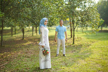 Fototapeta premium Happy Asian couple in love enjoying peaceful moment in nature. Romantic outdoor portrait.