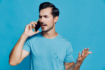 Confused man talking on mobile phone with puzzled expression, gesturing with hand, isolated on...