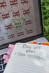 Notebook with tabs open on grass displays handwritten 'Day Off plan' starting with 'Happy morning',...