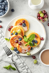 Cottage cheese pancakes with berries and condensed milk top view. Homemade dessert syrniki for healthy breakfast
