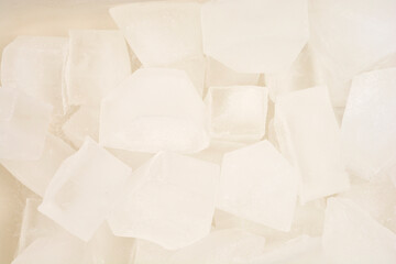 Obraz premium A pile of irregularly shaped, translucent ice cubes fills the frame, creating a refreshing texture