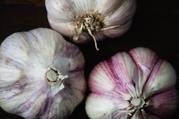 Cloves of unpeeled garlic close-up on a dark wooden table