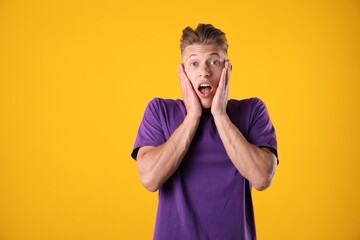 Portrait of surprised man on orange background, space for text