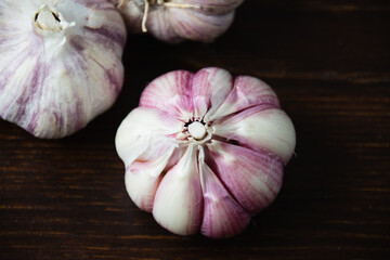Cloves of unpeeled garlic close-up on a dark wooden table