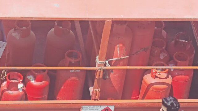 Rows of bright red cooking gas cylinders neatly stored, ready for distribution, symbolizing essential 