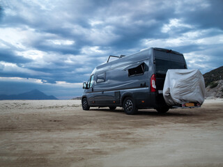 Camper van parked by the sea at dawn