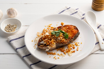 Fried Siriped catfish with garlic and pepper in white plate.Thai food.