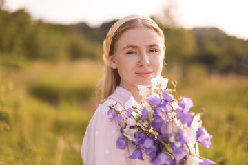 Beautiful woman with bouquet of wildflowers in meadow on sunny day. Space for text
