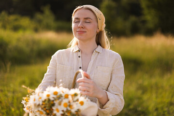 Happy woman with basket full of beautiful wildflowers outdoors