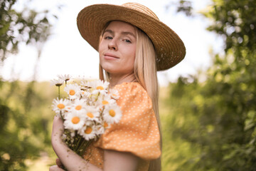 Beautiful woman with bouquet of wildflowers in forest