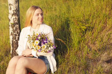 Woman with bouquet of beautiful wildflowers outdoors on sunny day. Space for text
