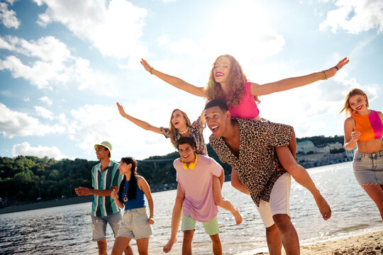 Young friends enjoying a sunny day outdoors together, engaging in fun activities by the water, celebrating friendship. - Powered by Adobe