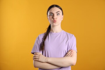 Portrait of shocked woman on orange background
