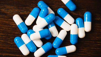 Many pills on a dark background macro. white and blue vitamin pills on a wooden background....