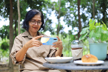 middle-aged woman enjoying coffee and pastry outdoors